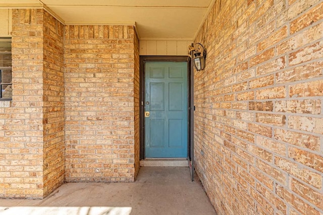 entrance to property featuring brick siding