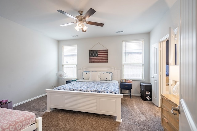 bedroom featuring visible vents, multiple windows, and dark colored carpet