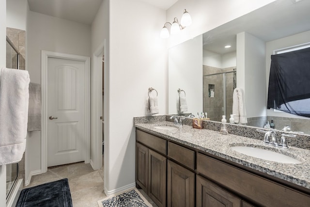 full bathroom featuring double vanity, baseboards, a stall shower, and a sink