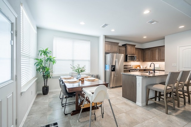 kitchen with stone countertops, visible vents, appliances with stainless steel finishes, and a sink