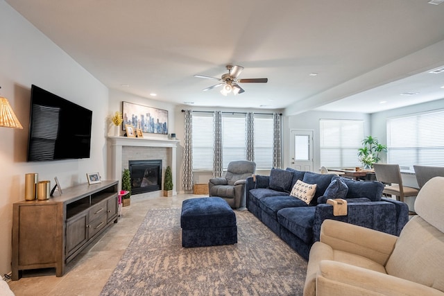 living room with recessed lighting, a ceiling fan, and a tile fireplace