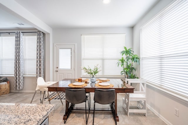 dining space featuring plenty of natural light, visible vents, and baseboards