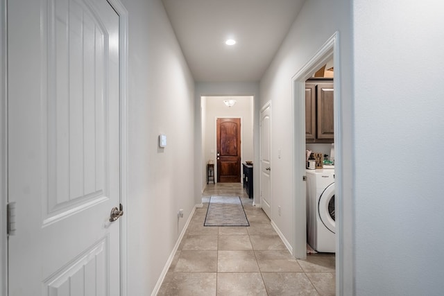 corridor with light tile patterned floors, washer / dryer, and baseboards