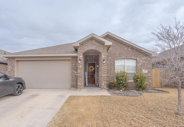 ranch-style home featuring a front yard, a shingled roof, concrete driveway, a garage, and brick siding