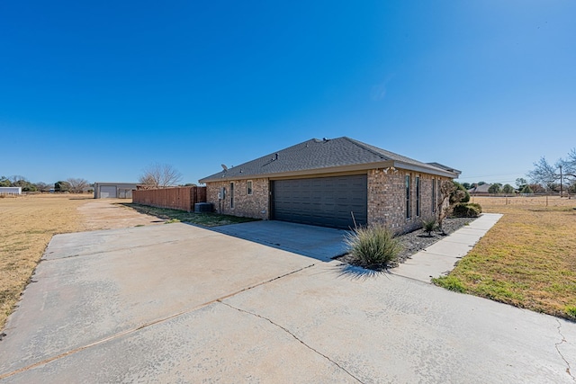 view of side of property featuring a garage and central air condition unit