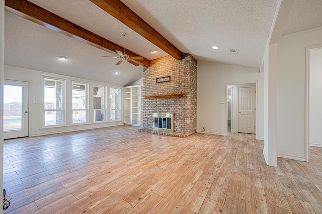 unfurnished living room with lofted ceiling with beams, a textured ceiling, light wood-type flooring, ceiling fan, and a fireplace