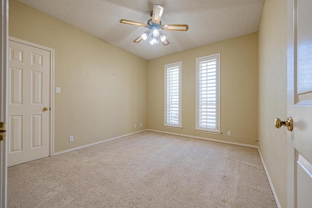 unfurnished room with ceiling fan, light carpet, and a textured ceiling