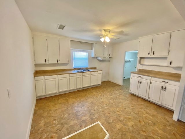 kitchen with white cabinets, ceiling fan, and sink