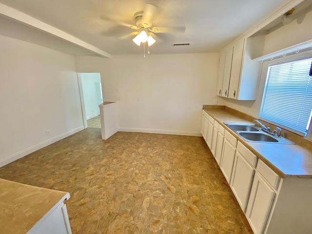 kitchen featuring white cabinets, ceiling fan, and sink