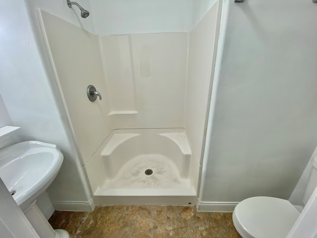 bathroom with toilet and a shower