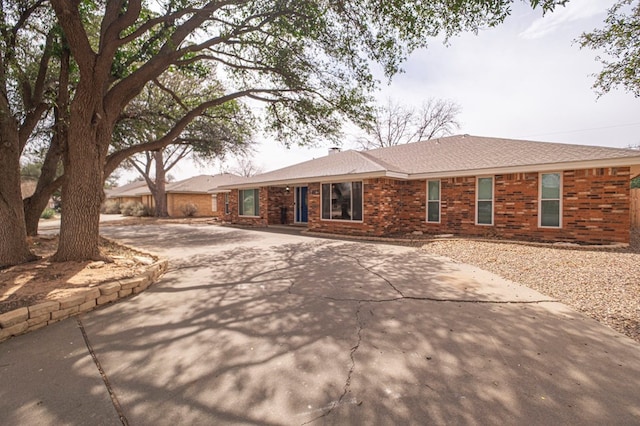 single story home with brick siding and driveway