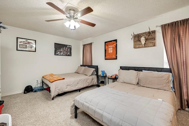 carpeted bedroom featuring baseboards, a textured ceiling, and a ceiling fan