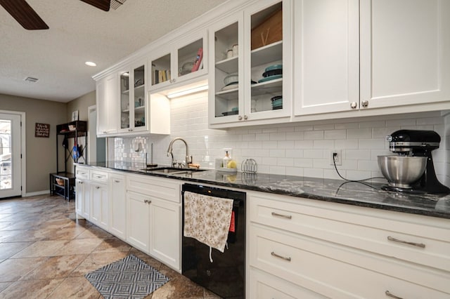 kitchen featuring a sink, black dishwasher, white cabinetry, dark stone counters, and decorative backsplash