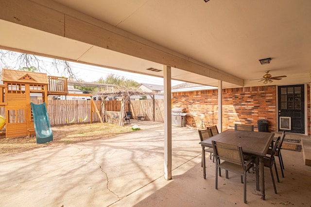 view of patio / terrace featuring outdoor dining space, fence, a playground, a grill, and ceiling fan