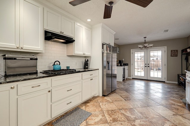 kitchen with gas cooktop, white cabinets, stainless steel refrigerator with ice dispenser, under cabinet range hood, and backsplash