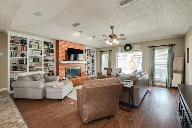 living area featuring dark wood finished floors, a fireplace, visible vents, and a textured ceiling