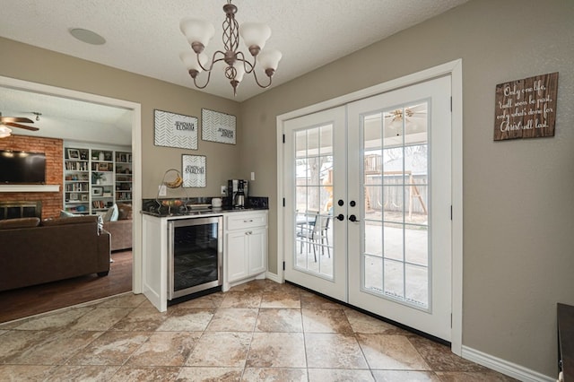 entryway featuring a fireplace, wine cooler, french doors, and a textured ceiling