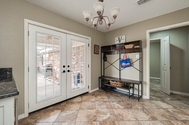 entryway featuring visible vents, a textured ceiling, french doors, baseboards, and a chandelier