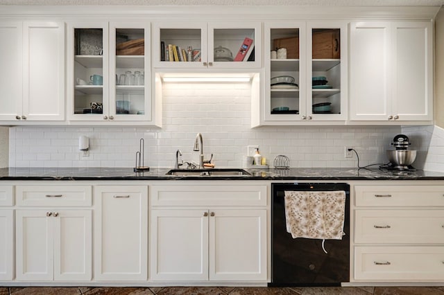 kitchen featuring white cabinetry, dark stone counters, a sink, glass insert cabinets, and dishwasher