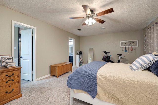 bedroom with visible vents, a textured ceiling, baseboards, light colored carpet, and ceiling fan