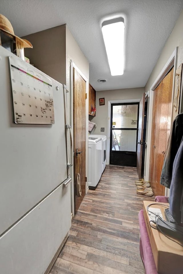 kitchen featuring a textured ceiling, dark hardwood / wood-style flooring, and washer and clothes dryer