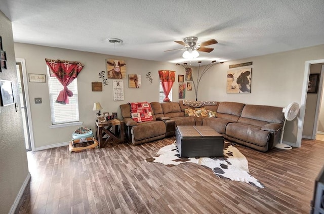 living room with ceiling fan, hardwood / wood-style floors, and a textured ceiling