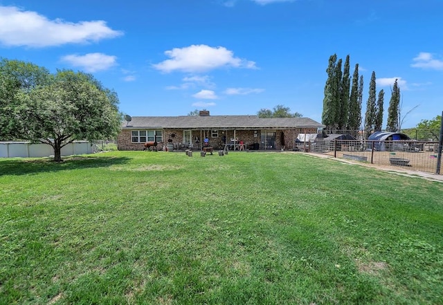 rear view of property featuring a yard