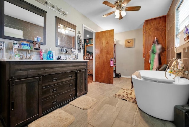 bathroom featuring a washtub, vanity, and ceiling fan