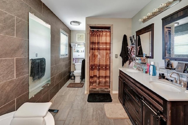 bathroom with toilet, tile walls, and a healthy amount of sunlight