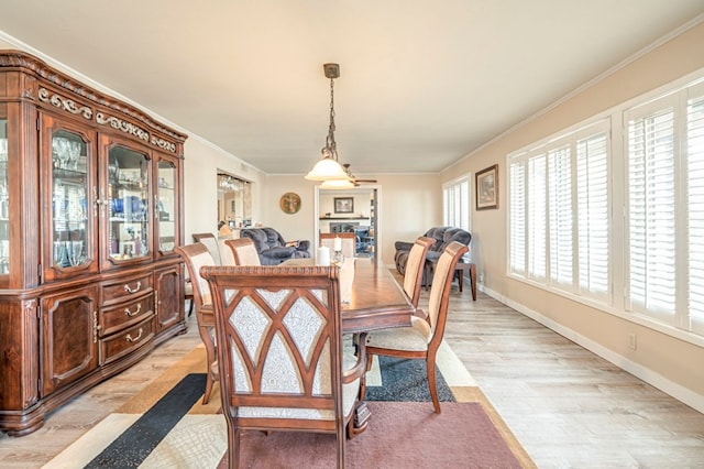 dining area with light hardwood / wood-style floors and ornamental molding