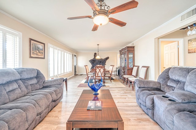 living room featuring ceiling fan, light hardwood / wood-style flooring, a healthy amount of sunlight, and ornamental molding