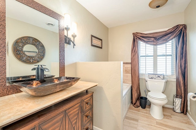 bathroom featuring wood-type flooring, vanity, and toilet