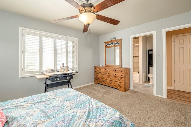 bedroom with ensuite bathroom, ceiling fan, and light carpet