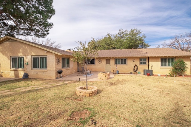 back of property with central AC, a patio area, and a yard