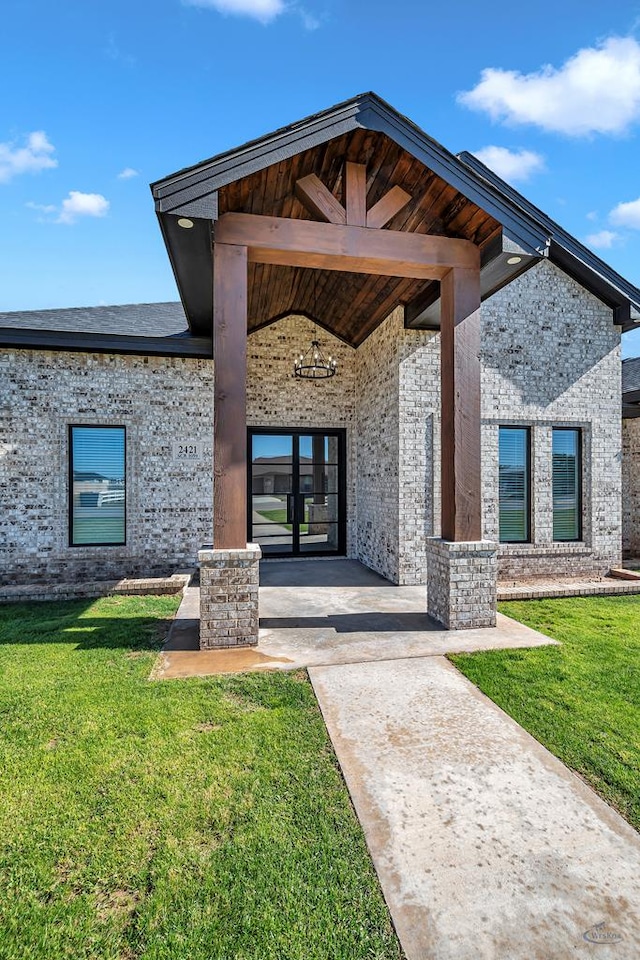 doorway to property featuring a lawn and french doors