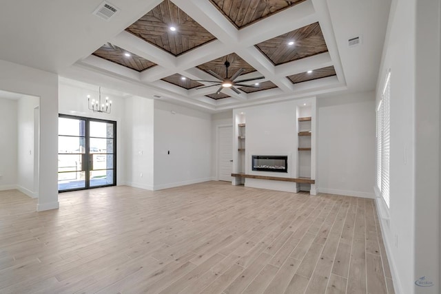 unfurnished living room with beamed ceiling, ceiling fan with notable chandelier, light wood-type flooring, and coffered ceiling