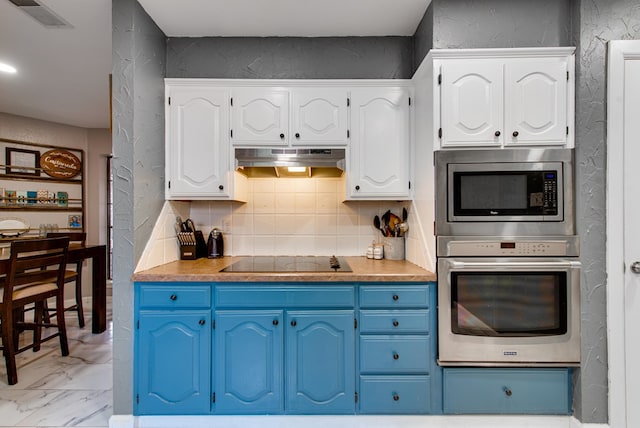 3906 Lehigh Dr, Midland, TX 79707 - kitchen with stainless steel appliances, under cabinet range hood, blue cabinetry, white cabinetry, and a textured wall