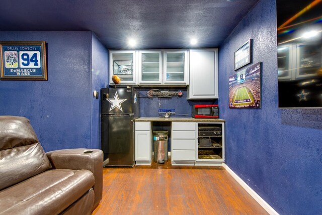 3906 Lehigh Dr, Midland, TX 79707 - indoor dry bar featuring freestanding refrigerator, dark wood finished floors, a textured wall, baseboards, and a textured ceiling