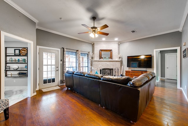 3906 Lehigh Dr, Midland, TX 79707 - living room featuring ceiling fan, ornamental molding, a brick fireplace, wood finished floors, and baseboards