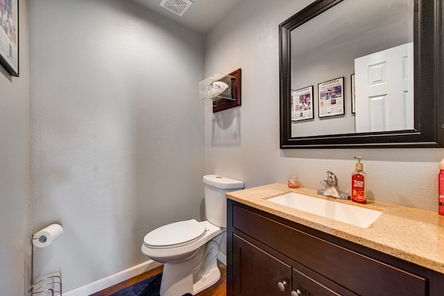 3906 Lehigh Dr, Midland, TX 79707 - half bathroom with toilet, vanity, baseboards, and wood finished floors