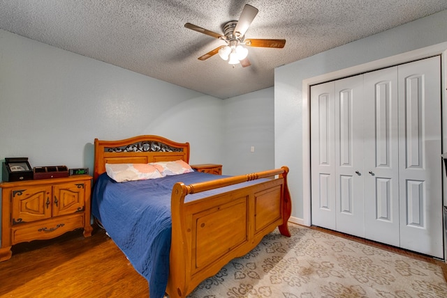 3906 Lehigh Dr, Midland, TX 79707 - bedroom featuring a textured ceiling, light wood finished floors, a closet, and a ceiling fan
