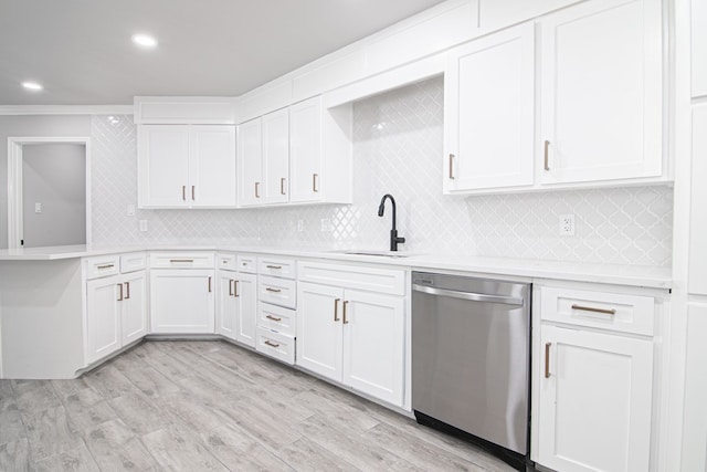 kitchen featuring ornamental molding, white cabinets, stainless steel dishwasher, and light wood-type flooring