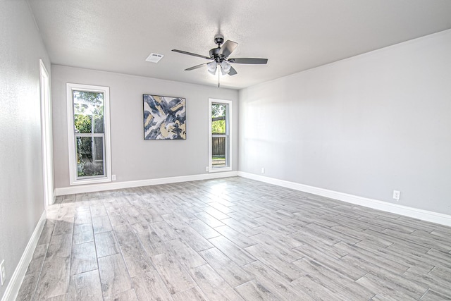 spare room featuring ceiling fan, light hardwood / wood-style floors, and a textured ceiling