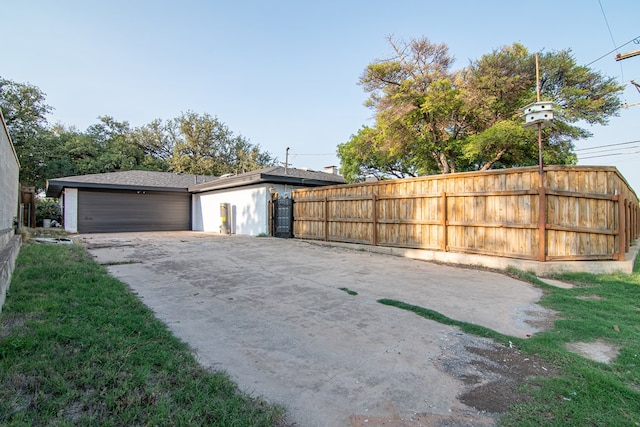 garage with driveway and fence