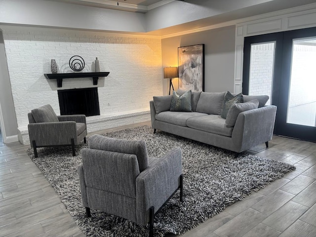 living room featuring a brick fireplace and wood finished floors