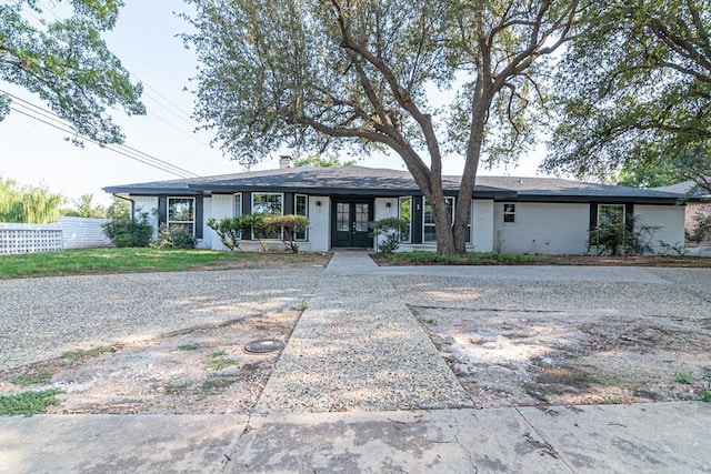 ranch-style home featuring french doors and fence