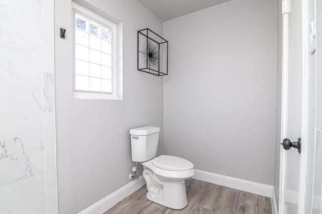 bathroom with baseboards, toilet, and wood tiled floor