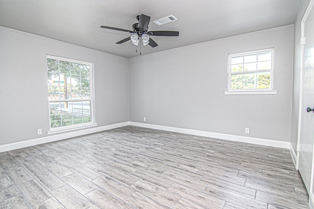 empty room with ceiling fan, light wood-type flooring, and a textured ceiling