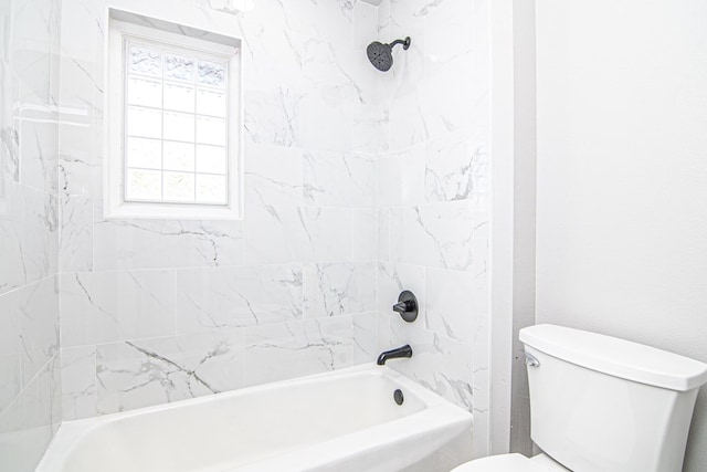 bathroom featuring toilet and tiled shower / bath