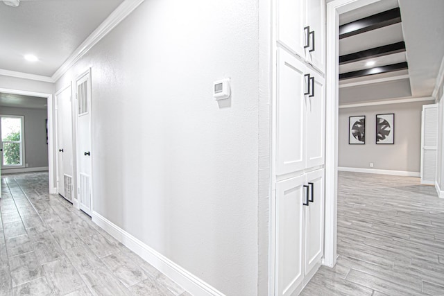 hallway featuring crown molding, beamed ceiling, and light hardwood / wood-style floors